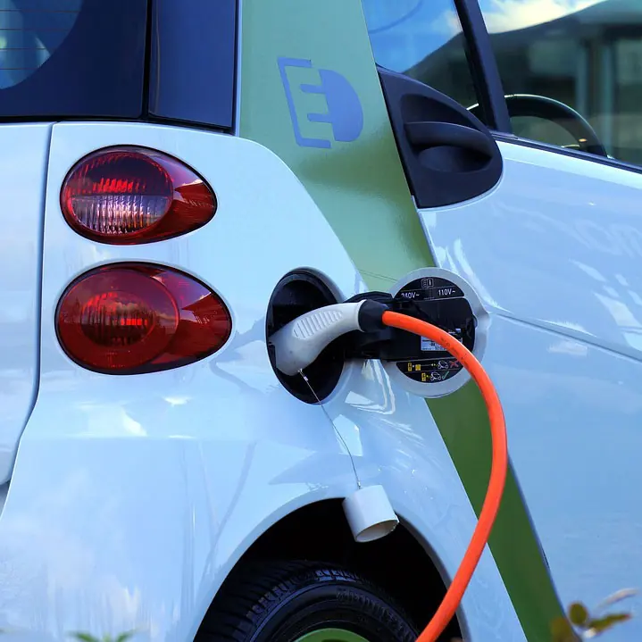A charging cable plugged into a small electric car